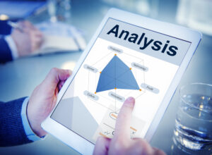 Business professional analyzing performance metrics and innovation opportunities on a digital tablet, concept of predictive analytics and quality assessment.